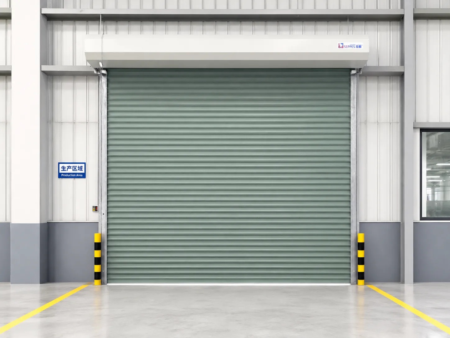 Green steel roller door installed at a manufacturing production area entrance