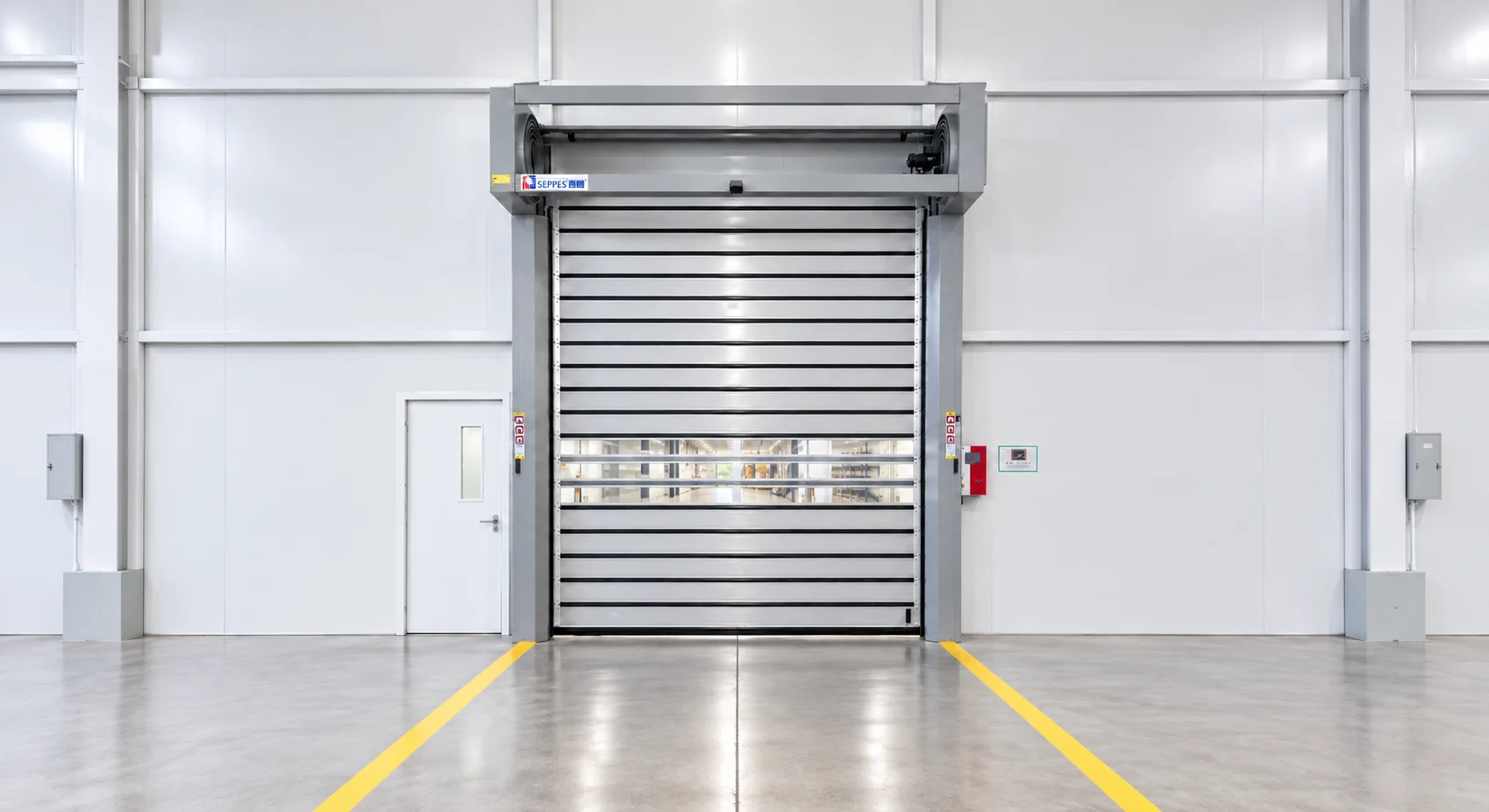 Rigid panel high speed doors along a factory aisle